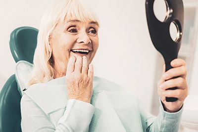 woman loving her dental implants from DentaCare Dental Group Longview